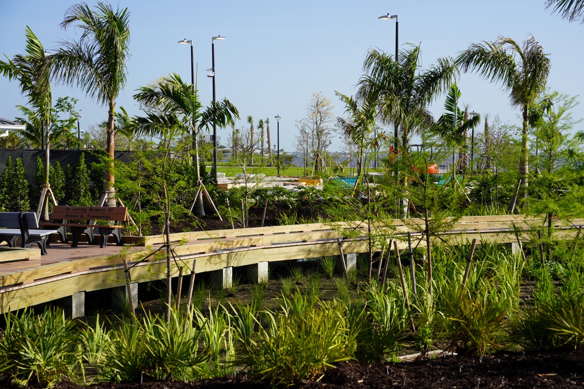 Close view along the curved waterfront boardwalk at Jaycee Park looking out over the river on a clear day.